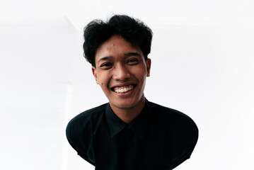 Obraz premium Smiling Young Man in Black Shirt Portrait in Bright Studio Setting for Friendly Brand Image