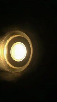 Vertical video: Tracking recessed downlight as camera slightly shifting frame, showing lens halo