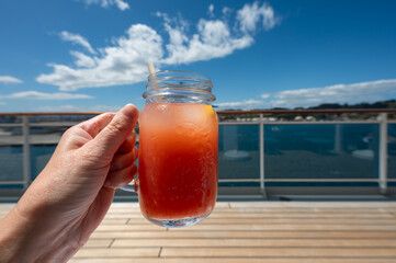 Glass of Fresh Grapefruit Juice in Hand. Refreshing Beverage on Cruise Vacation.