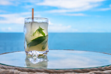 Refreshing Cocktail with Mint Leaves and Lime Served by the Seaside. Summer Drink and Relaxation Concept.