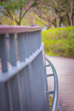 Metal pedestrian railing on a sunlit walkway.