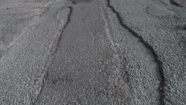 Potholes on damaged asphalt road in need of repair