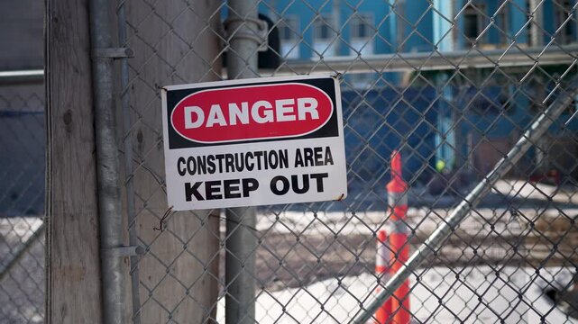Signs state danger and keep out at Minnesota Transportation Building in St Paul near construction site with visible barriers.