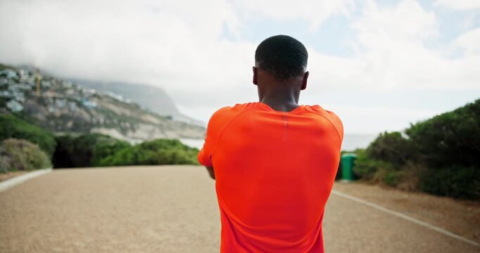 Warm up, runner and back of man in nature for marathon race, exercise and health. Workout, wellness and cardio with person training at park for sports athlete, challenge and fitness stretching