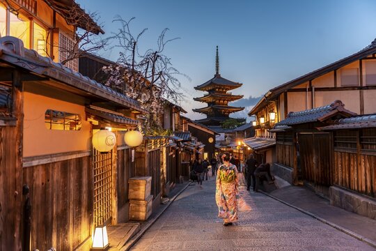 Woman in kimono in a lane, Yasaka dori historical alleyway in the old town with traditional Japanese houses, behind five-storey Yasaka pagoda of the Buddhist Hōkanji temple, evening mood, Kyoto, Japan