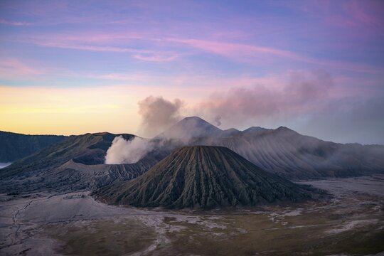 Volcanic landscape at sunrise, smoking volcano Gunung Bromo, with Mt. Batok, Mt. Kursi, Mt. Gunung Semeru, Bromo-Tengger-Semeru National Park, Java, Indonesia