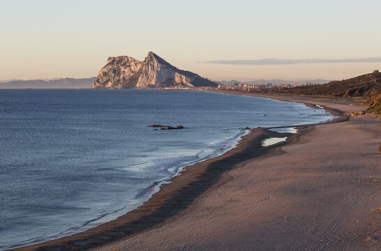 View of The Rock of Gibraltar and La Linea de la Concepcion as seen from the Mediterranean coast in the early morning light, Cadiz, Andalusia, Spain