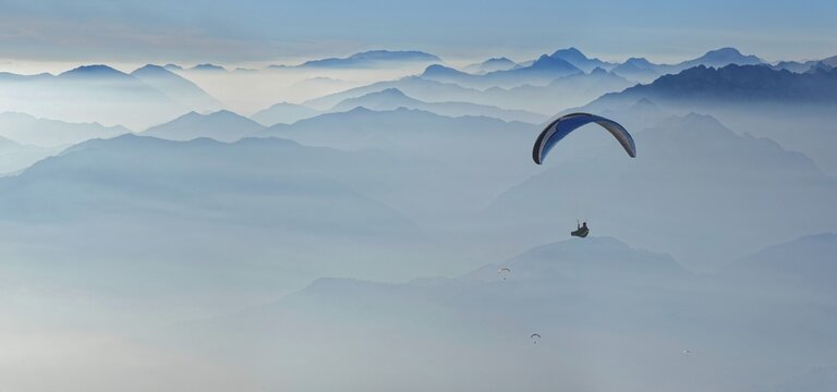 Paragliding with the peaks of the Garda Mountains and Bergamo Alps, Monte Baldo, Malcesine, Verona Italy, Trentino-Alto Adige, Italy