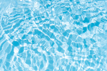 Obraz premium Bluewater waves on the surface ripples blurred. Defocus blurred transparent blue colored clear calm water surface texture with splash and bubbles. Water waves with shining pattern texture background.
