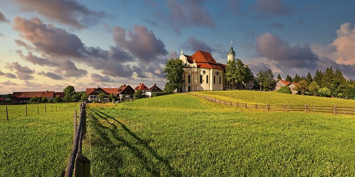 Pilgrimage church of the Scourged Saviour on the Wies with cloudy sky in the evening, rock garden, Pfaffenwinkel, Bavaria, Germany
