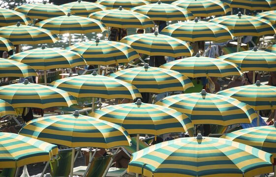 Strung colorful striped umbrellas on the beach, Sestri Levante, Liguria, Italy