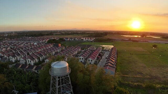 Golden sunset bathes Tierra Vista and Nueva Estancia in Cavite, Philippines, as a drone gracefully orbits above homes and fields. This cinematic aerial captures peaceful suburban living