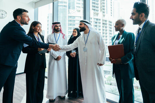 Diverse business team shaking hands during corporate meeting in dubai
