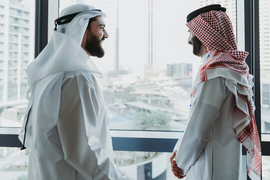 Emirati and saudi businessmen discussing partnership in modern office