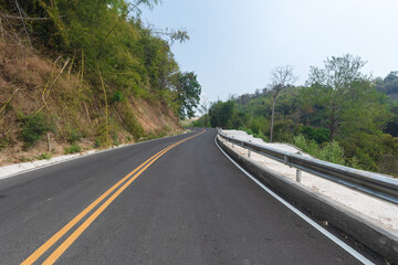 Obraz premium Beautiful curved road in the forest. Road background.