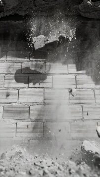 Vertical video: Broken lintel giving way, central dust column descending brick wall during demo