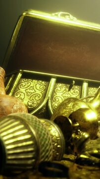 A treasure chest is open to show gold coins and various artifacts. The scene is dimly lit, and the treasure is scattered around. Glimmers of gold create a striking view.