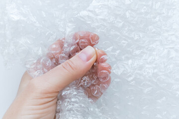 Fototapeta premium Hand Squeezing Bubble Wrap Close Up
