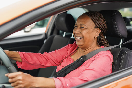 Happy african senior woman smiling while driving a car - Transportation, insurance and elderly person concept - Focus on face