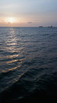 Aerial View of Calm Sea Sunset with Cargo Ships on the Horizon