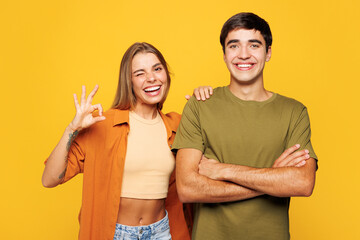 Fototapeta premium Young happy couple friends family man woman wears shirt casual clothes together put hand on shoulder look camera isolated on pastel plain light yellow background studio portrait. Lifestyle concept