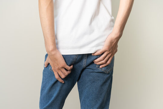 Closeup annoying itch asian man with an itchy his butt from fungal, male scratching crotch with hand, itching groin, male suffering body problem. Health care, hygiene, skin disease, medicine concept