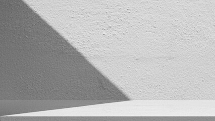 Fototapeta premium Empty white concrete wall and floor with aesthetic natural shadow for product display mockup. Minimalist studio background with cement texture for showcase in sunlight.