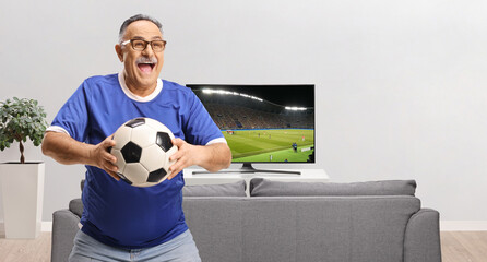 Happy man in a blue jersey holding a football