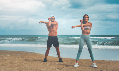 Young healthy Yoga woman and man workout yoga pose on the beach at sunset