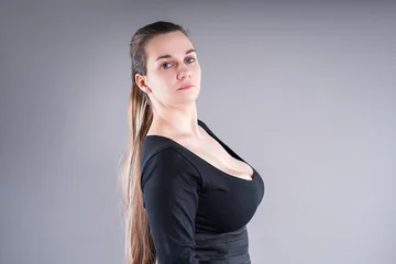 Curvy plus size fashion model in black bodysuit on gray background © staras