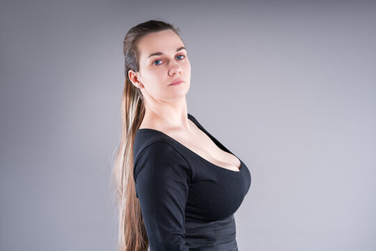 Curvy plus size fashion model in black bodysuit on gray background
