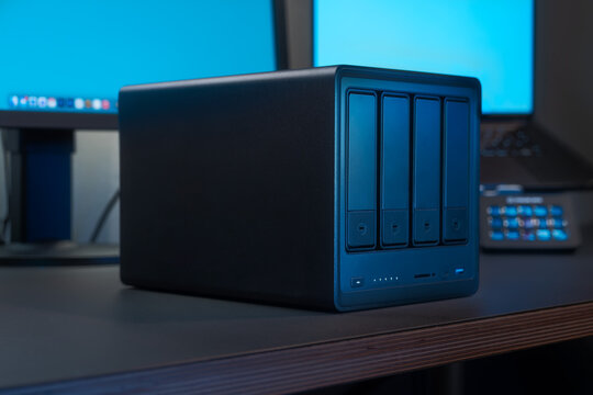 Blue NAS Server With Four Drive Bays On Desk For Storage And Backup