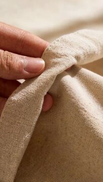 Right hand pinching and lifting folded edge, rolling hem into tunnel and smoothing seam for sewing