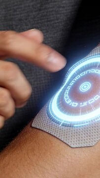 Man sweeping palm over arm patch for health, activating lit ring, tapping revealing settling rings