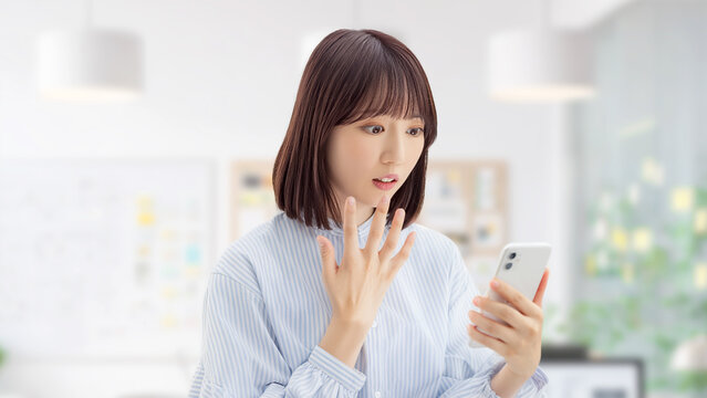 スマートフォンを見て驚くビジネスウーマン 予想外の知らせのビジネスイメージ, Businesswoman Surprised Looking at Smartphone Unexpected News Concept