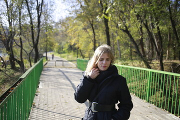 Fototapeta premium A young woman walks through the autumn park.