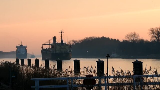 Frachter fahren bei Sonnenaufgang im Nord-Ostsee-Kanal