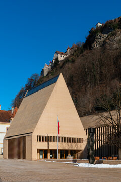 View of the striking Kunstmuseum Liechtenstein with its modern, monolithic architecture standing boldly against the rocky backdrop of the castle, Vaduz, Vaduz, Liechtenstein.