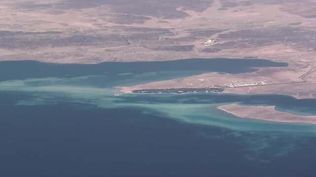 4k aerial video footage flying along Saudi Arabian Red Sea coastline near Sharma and Alkhuraybah in northwest Saudi Arabia with beaches, gulf course, islands, and  desert landscape in the background