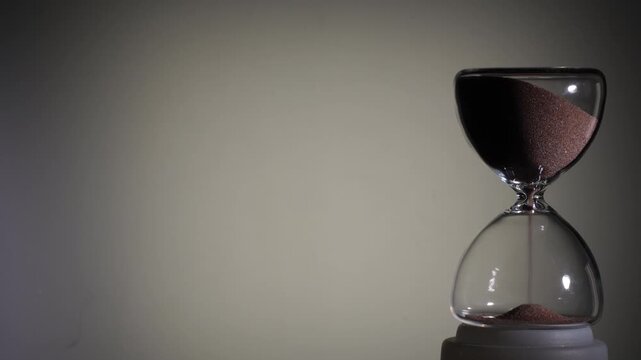 Hourglass flowing on white background. Right align comp with copy space on top and left, time management concept, minimalist product shot, hourglass in motion, clean style, starting to flow
