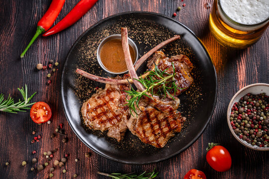 Top view grilled lamb chops with rosemary and beer on rustic table