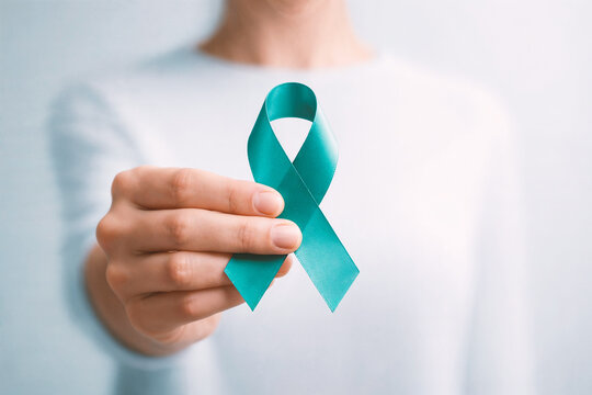 Teal awareness ribbon held in hand. Mental health, PTSD, OCD, Tourette syndrome support concept
