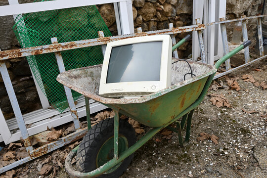 old computer abandoned outdoors in wheelbarrow