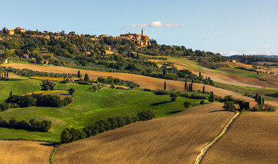 Naklejka premium Pienza townscape over rolling Tuscan hills and cultivated fields, Italy.