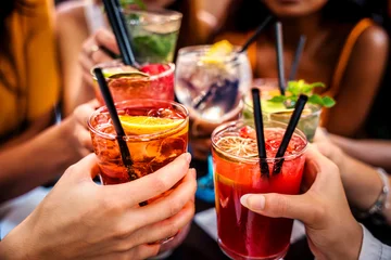 Fotobehang Bar Happy people toasting cocktail glasses sitting at bar table - Cheerful friends enjoying happy hour at pub restaurant balcony - Food and beverage life style concept  © Davide Angelini