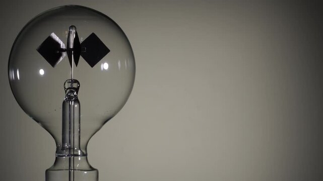 Left align, rotating Crookes radiometer light mill on bright white background. Soft glow start. High-key lighting, minimalist science experiment, solar vane, physics education, right copy space
