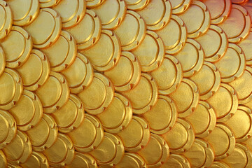 Gold patterns of stucco shaped like fish scales. © meepoohyaphoto