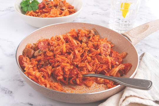 Bigos, Polish dish bigos, on the table, pan with stewed meat, with cabbage, chorizo sausages, mushrooms, homemade, without people,