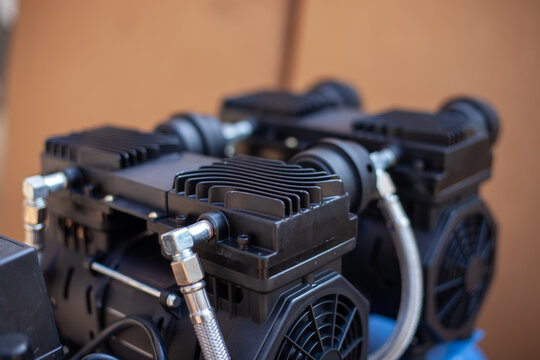 Top view of a portable oil-free air compressor with dual motor blocks, pressure regulator, and blue receiver tank for professional workshop, dental clinic, and industrial pneumatic power applications.