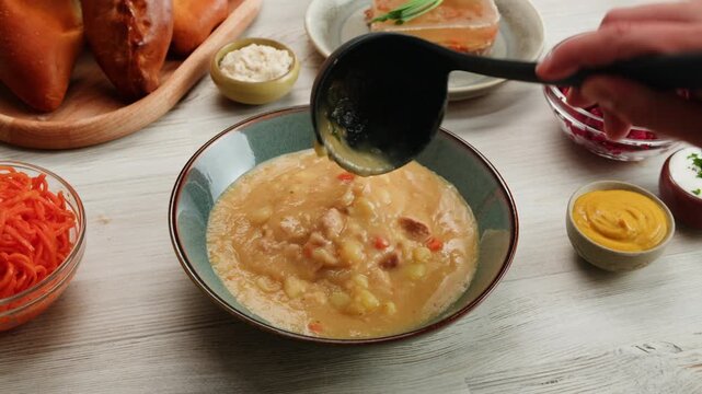 Split pea soup, Eating mashed pea soup with sausages and pork. Popular german or slavic food, winter street food.